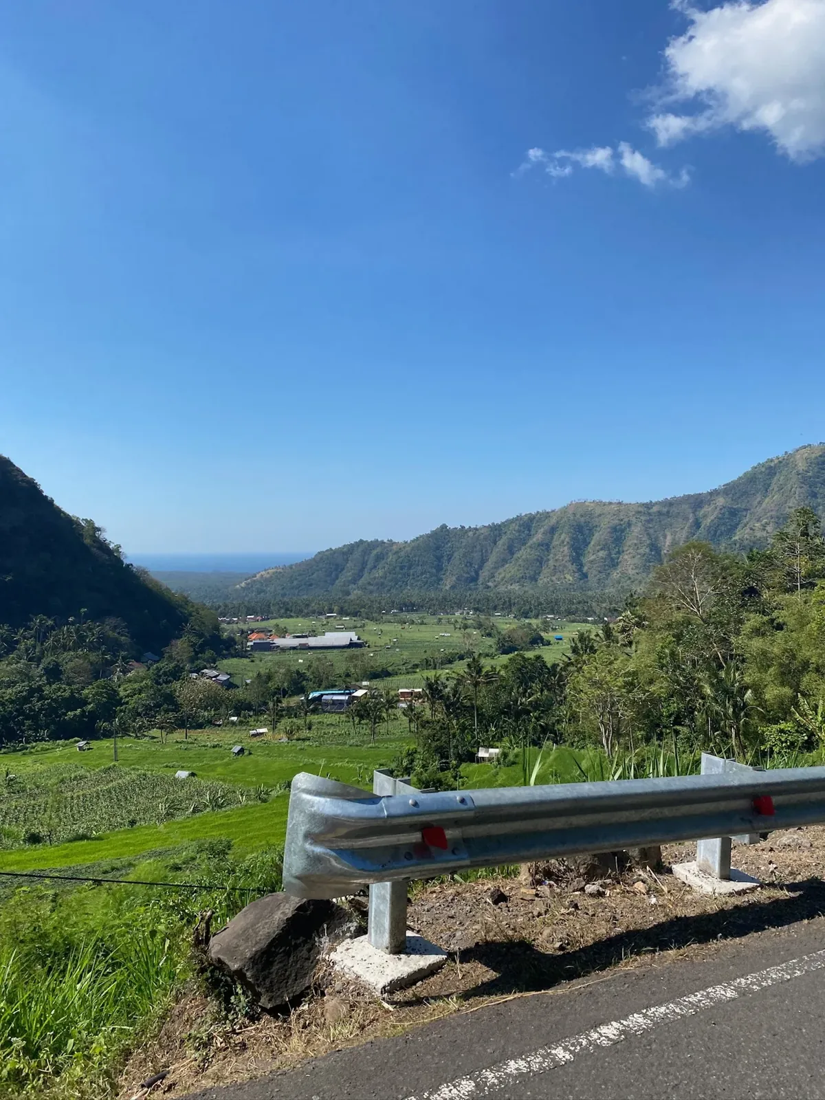 Sur la route en scooter, une vallée de rizières qui descend jusqu'à la mer.