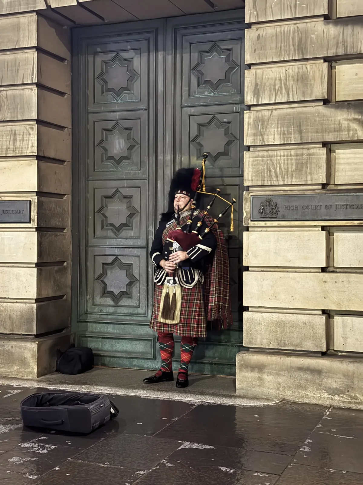 Édimbourg : un joueur de cornemuse sous une porte, comme dans les clichés.
