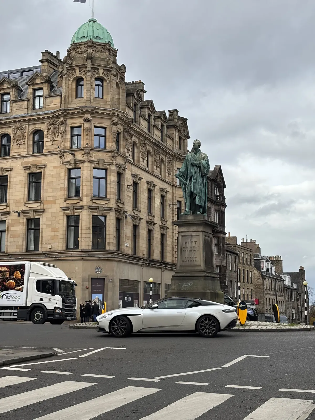 Princes Street, statue, dôme vert et ciel gris.