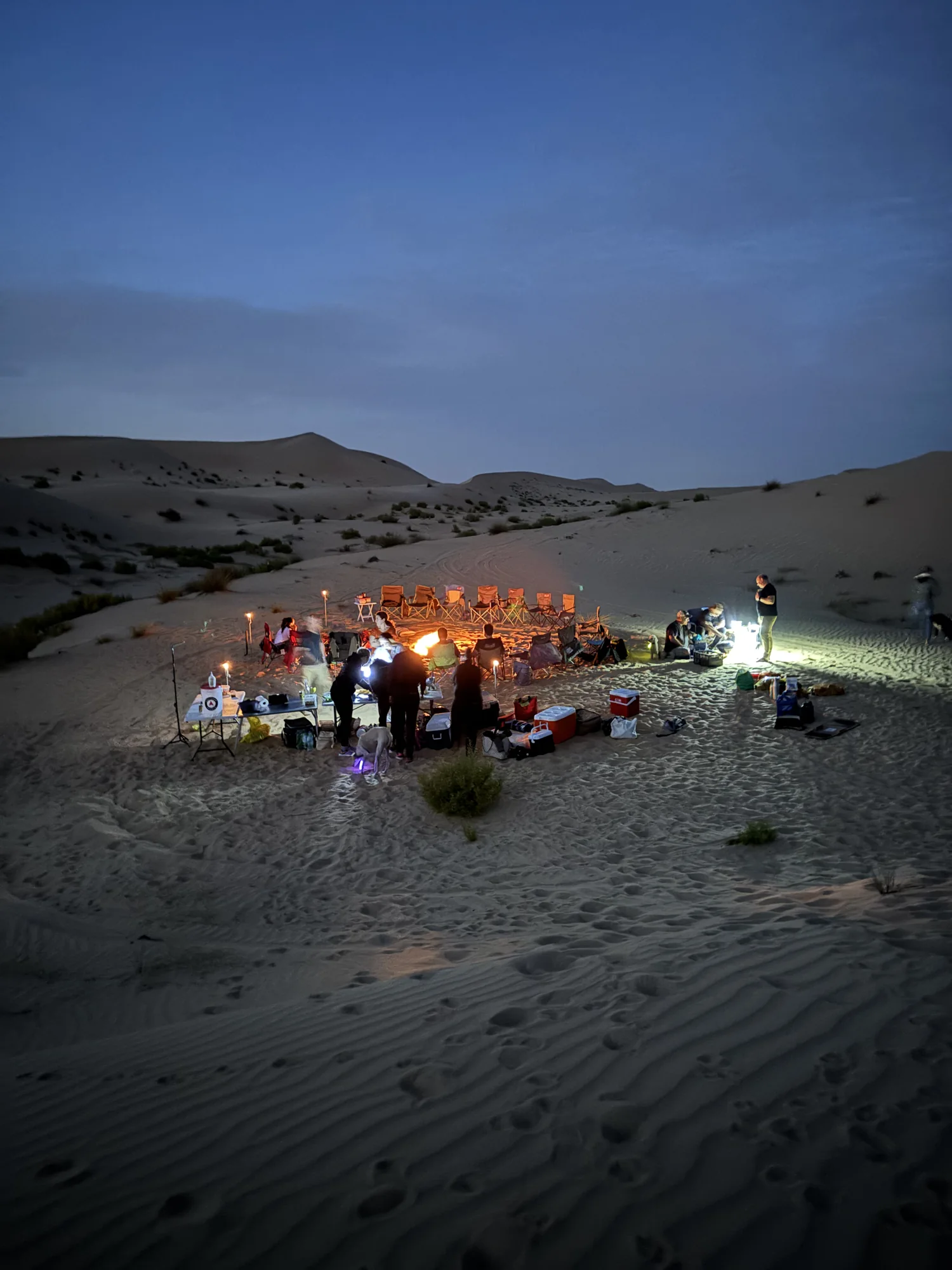 Le camp, le soir, avec le feu au milieu de nulle part.