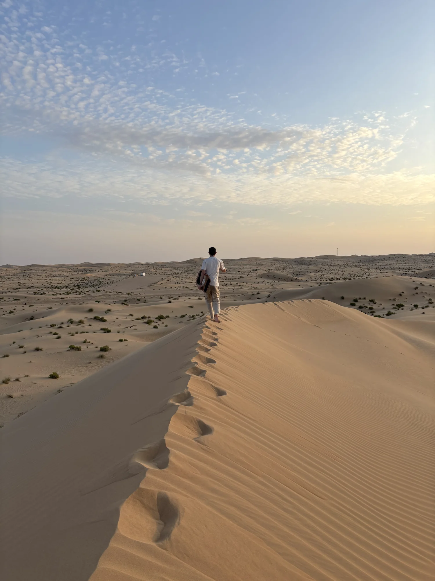 Seul sur la crête d'une dune, au coucher du soleil.