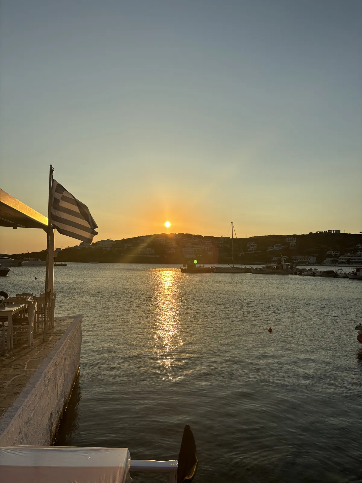 Coucher de soleil sur le port, le drapeau grec au premier plan.