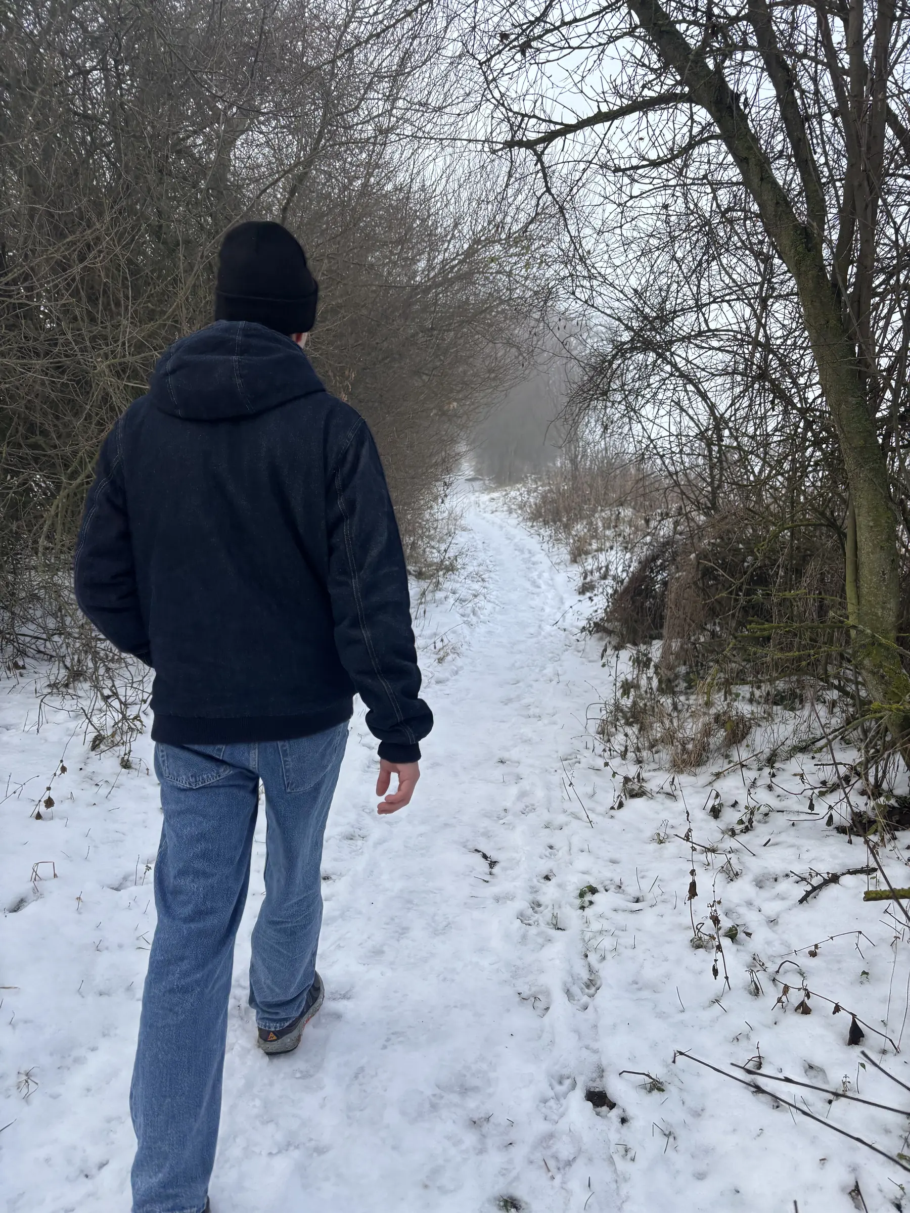 Un chemin de neige entre les arbres, à la sortie du village.