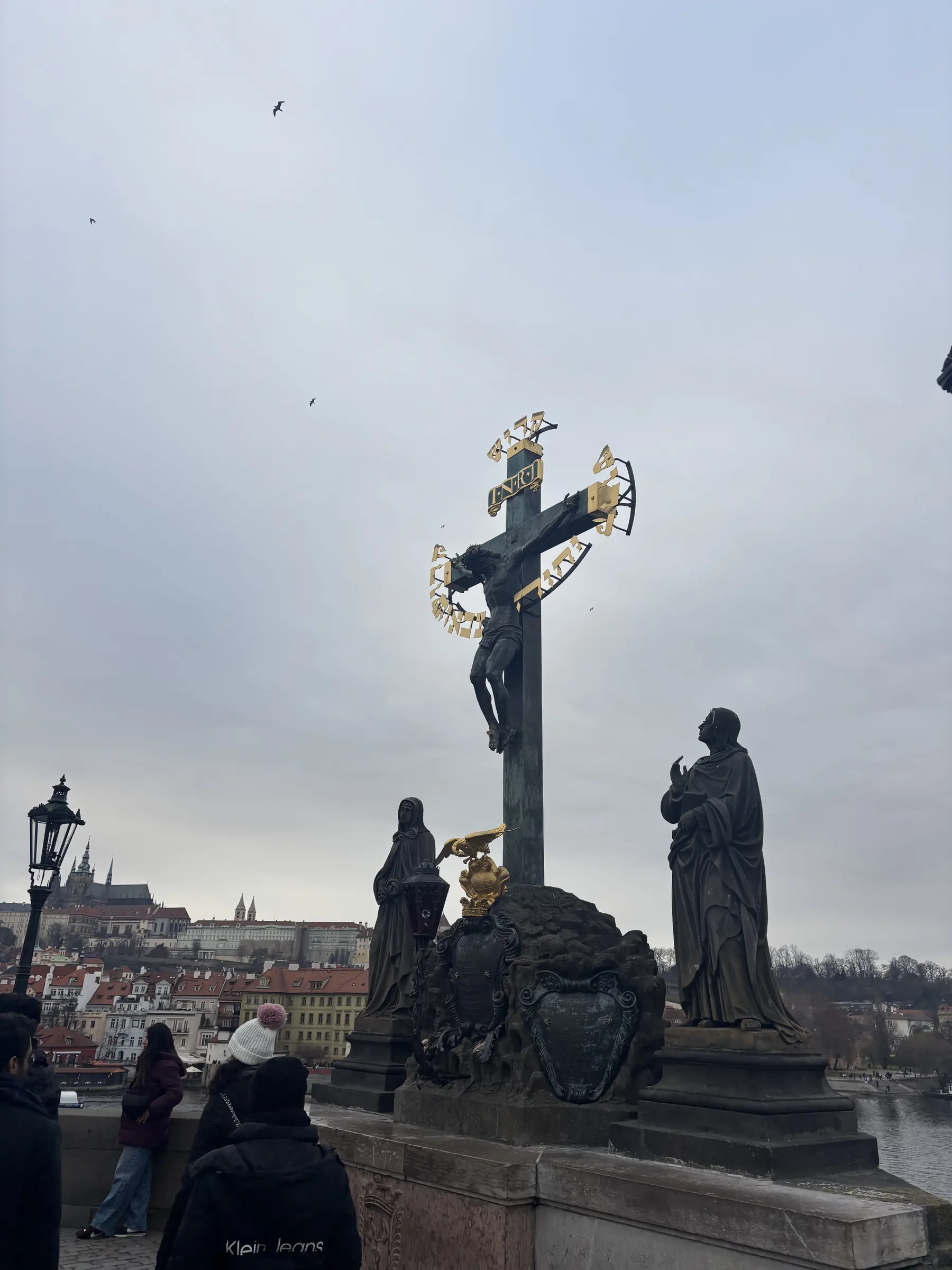 Sur le pont, l'un des trente statues : le crucifix et ses lettres dorées.