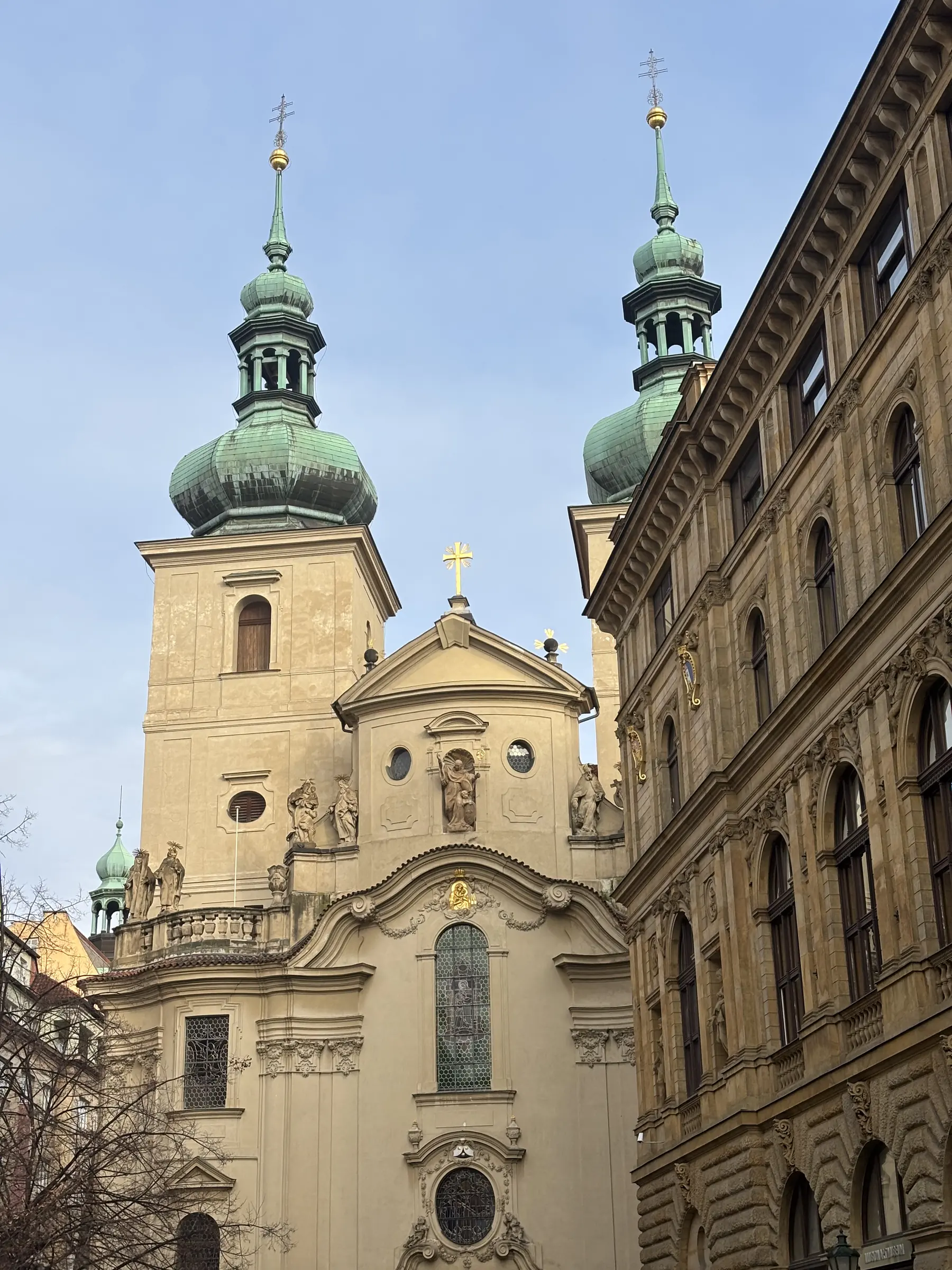 Les bulbes verts d'une église coincée entre deux immeubles.