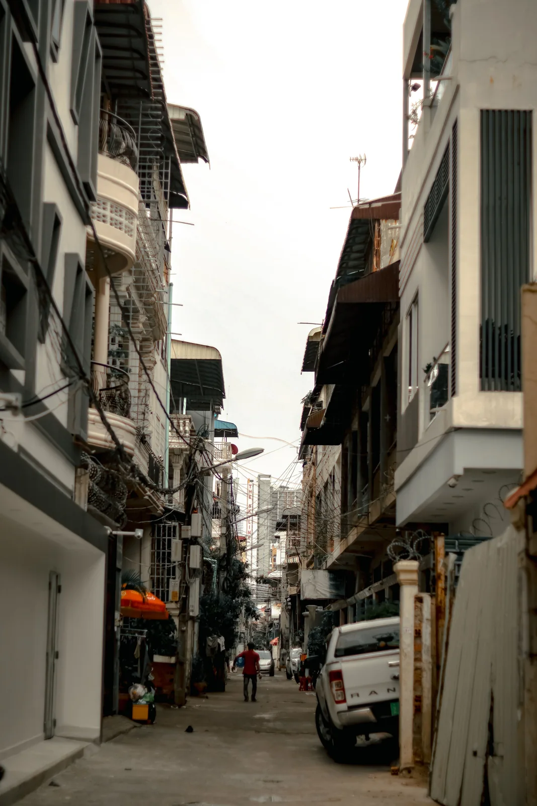 Une ruelle de Bangkok, câbles, balcons et pick-up.
